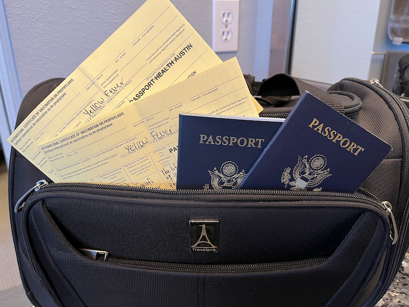 Yellow fever immunization cards and passports in black carry-on bag