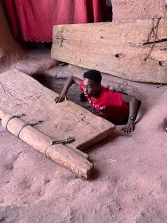 Sam coming out of stone church tunnel in Lalibela, Ethiopia