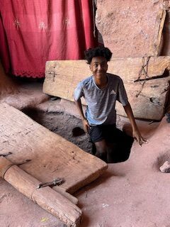 Micah coming out of stone church tunnel in Lalibela, Ethiopia